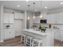 Bright kitchen features an island with seating, pendant lighting, and stainless steel appliances at 82 Fairwinds Dr, Lillington, NC 27546
