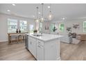 Open kitchen showcasing a large island, pendant lights, stainless sink, and flow into the living area at 82 Fairwinds Dr, Lillington, NC 27546