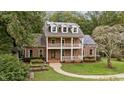 Attractive two-story brick home with double balconies, solar panels, and a well-manicured lawn at 1017 Holly Creek Ln, Chapel Hill, NC 27516