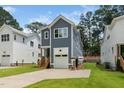 Side view of a two-story home with a blue exterior, showcasing the driveway and adjacent green lawn at 1211 Chaney Rd, Raleigh, NC 27606