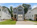 The front of a two-story home features blue siding, white trim, an integrated garage, and lush lawn at 1211 Chaney Rd, Raleigh, NC 27606
