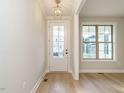 Bright foyer features hardwood floors, white trim, and a stylish pendant light fixture at 1245 Barreto Dr, Wendell, NC 27591
