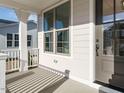 Inviting front porch with stylish gray front door, classic white columns and painted gray siding at 1245 Barreto Dr, Wendell, NC 27591