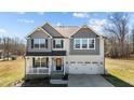 Charming two-story home featuring gray and white siding and a welcoming front porch at 1318 Reading Ct, Burlington, NC 27217