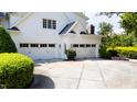 Attached three-car garage with white doors and manicured landscaping at 1416 Barony Lake Way, Raleigh, NC 27614