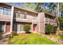 Inviting townhome showcasing a red front door, manicured shrubs and healthy green lawn at 1738 Quail Ridge Rd, Raleigh, NC 27609
