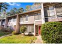 Inviting townhome showcasing a red front door, manicured shrubs and healthy green lawn at 1738 Quail Ridge Rd, Raleigh, NC 27609