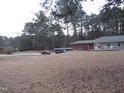 Sprawling ranch-style home with brick and stone accents, surrounded by a large yard and mature trees at 2506 Poole Rd, Raleigh, NC 27610