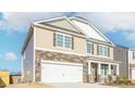 Two-story home featuring stone and siding, two car garage, and a covered front porch at 2561 Summersby Dr, Mebane, NC 27302