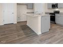 Kitchen island featuring granite countertops, gray cabinets, stainless steel appliances at 262 Palm Dr, Sanford, NC 27332