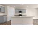 Modern kitchen featuring gray cabinets, granite countertops, and a central island at 262 Palm Dr, Sanford, NC 27332