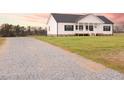 Gravel driveway leading to a charming home with a covered porch and lovely landscaping at 29 Hinshaw Shop Rd, Liberty, NC 27298