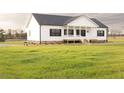 Beautiful single-story home featuring a covered front porch and a well-manicured lawn at 29 Hinshaw Shop Rd, Liberty, NC 27298