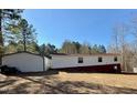 A view of the back of the home showing the large detached garage and the sloped lawn at 328 Cone Dr, Henderson, NC 27537
