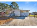 A one-story home with a large driveway and a partially screened patio addition at 409 S 13Th St, Lillington, NC 27546