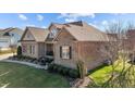 Brick home featuring a manicured lawn, covered porch, and elegant design at 4278 Aviemore, Burlington, NC 27215