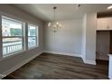 Bright dining room featuring wood floors, natural light from large windows and a modern chandelier at 500 Yeowell Dr, Chapel Hill, NC 27514