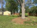 Backyard with privacy fence and mature shade tree on a sunny day at 531 N Main St, Graham, NC 27253