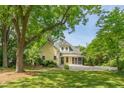 Inviting yellow home with mature trees, a spacious yard, and a charming front porch at 531 N Main St, Graham, NC 27253