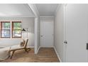 Hallway showcasing wood-look floors, neutral walls, and a stylish chair near a window at 5400 Cedarwood Dr, Raleigh, NC 27609