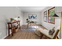 Bright home office with a modern glass desk, neutral walls, wood-look floors, and natural light from the window at 5400 Cedarwood Dr, Raleigh, NC 27609