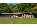 Charming brick home with a well-manicured lawn and modern design elements, under a bright, sunny sky at 5601 Lambshire Dr, Raleigh, NC 27612