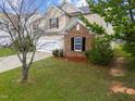 Charming home with a brick accent, manicured lawn, and blossoming tree in the front yard at 6013 Shelane Ct, Raleigh, NC 27610