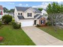 Attractive two-story home with a long driveway, attached garage, and mature landscaping at 6013 Shelane Ct, Raleigh, NC 27610
