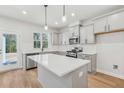 Bright, open kitchen featuring gray cabinets, stainless steel appliances, and a spacious white countertop island at 624 Brittany Ct, Durham, NC 27703