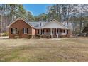 Traditional brick home featuring a covered front porch and lush front lawn at 6709 Windchase Dr, Rocky Mount, NC 27803