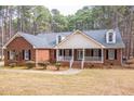 Classic brick home with inviting covered front porch and well-maintained landscaping at 6709 Windchase Dr, Rocky Mount, NC 27803