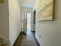 Bright hallway with hardwood floors, an open front door, and a decorative painting on the wall at 7780 Brookdale Dr, Raleigh, NC 27616