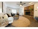 Cozy living room with brick fireplace, ceiling fan, and comfortable seating area at 7780 Brookdale Dr, Raleigh, NC 27616