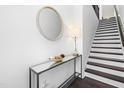 Modern entryway with a round mirror, stylish console table, and staircase leading to the upper level at 8401 Zinc Autumn Path Path, Raleigh, NC 27615