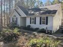 Well-maintained single-story home featuring light siding, black shutters, and landscaped front yard at 90 Wembley Ct, Youngsville, NC 27596