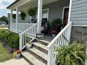 Cozy covered front porch, furnished with chairs, hanging ferns, and welcoming decor at 94 Aylebury Rdg, Zebulon, NC 27597