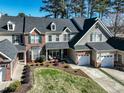 Aerial view of townhomes with manicured lawns, attached garages and mature trees surrounding the neighborhood at 10115 Mizner Ln, Raleigh, NC 27617