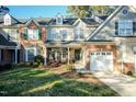 Charming two-story home with manicured front yard and cozy front porch that has decorative plants and seating at 10115 Mizner Ln, Raleigh, NC 27617