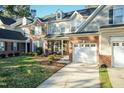 Charming two-story home with manicured front yard and cozy front porch with decorative plants and seating at 10115 Mizner Ln, Raleigh, NC 27617