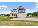 New construction two-story home featuring a wide driveway, attached garage, and manicured lawn at 108 Grove Township Way, Angier, NC 27501