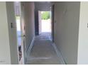 Well-lit hallway with neutral walls, leading to an open door and an outside view, great for navigation at 108 Grove Township Way, Angier, NC 27501