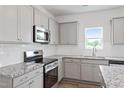 Modern kitchen featuring granite countertops, stainless steel appliances, and subway tile backsplash at 108 Grove Township Way, Angier, NC 27501
