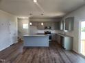 Open kitchen with granite countertops, stainless steel appliances, and wood flooring at 108 Grove Township Way, Angier, NC 27501
