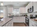 Modern kitchen with white cabinets, granite countertops, and stainless steel appliances at 119 Grove Township Way, Angier, NC 27501