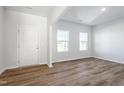 Bright living room featuring hardwood floors, two large windows, and fresh white walls for a modern, airy feel at 119 Grove Township Way, Angier, NC 27501