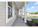 Covered porch featuring classic white columns and brick, adding to the home's architectural charm and curb appeal at 119 Grove Township Way, Angier, NC 27501
