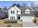 Charming two-story home features white siding, a gray roof, an attached garage, and manicured landscaping at 130 Silent Brook Trl, Franklinton, NC 27525
