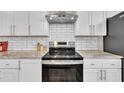 The kitchen features white cabinets, stainless steel appliances, granite countertops, and a stylish subway tile backsplash at 1521 Chapel Hill Rd, Durham, NC 27701