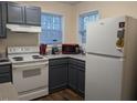 Updated kitchen featuring modern appliances including white refrigerator and stove, and gray cabinets at 1911 Wolftech Ln # 303, Raleigh, NC 27603