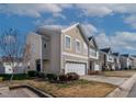 Attractive beige two-story home with a two-car garage and well-maintained landscaping at 1952 Grassy Banks Dr, Raleigh, NC 27610